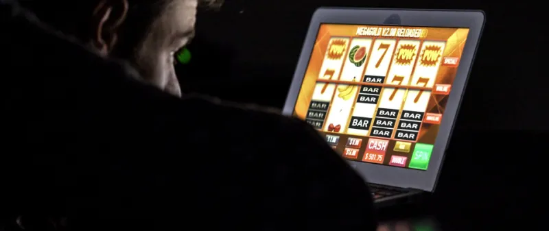 Decorative image: Man looking at gambling slot screen on tablet