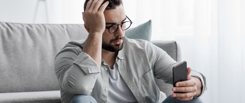 Decorative image - Man looking at phone reading