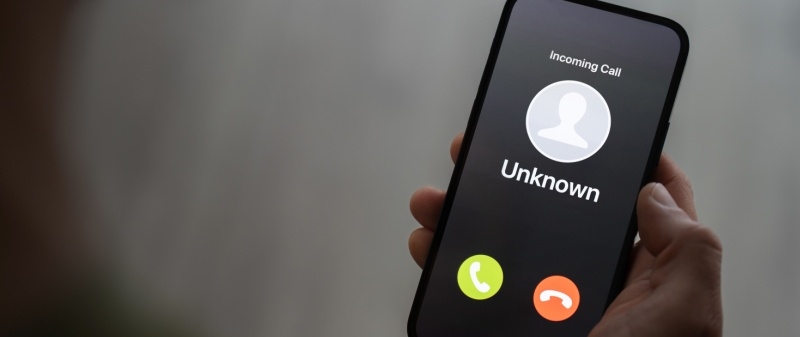 Decorative image - Person holding mobile phone receiving call from unknown source