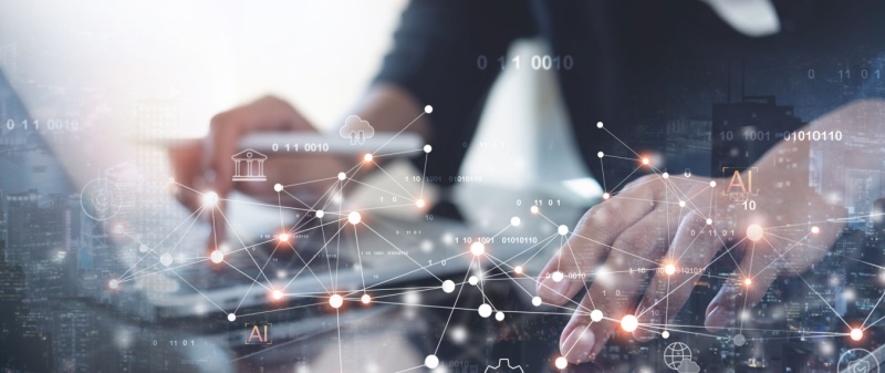 Decorative image - Person typing on computer, with interconnectivity graphics superimposed on photo