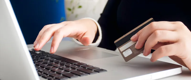 Decorative image - Person using laptop holding credit card
