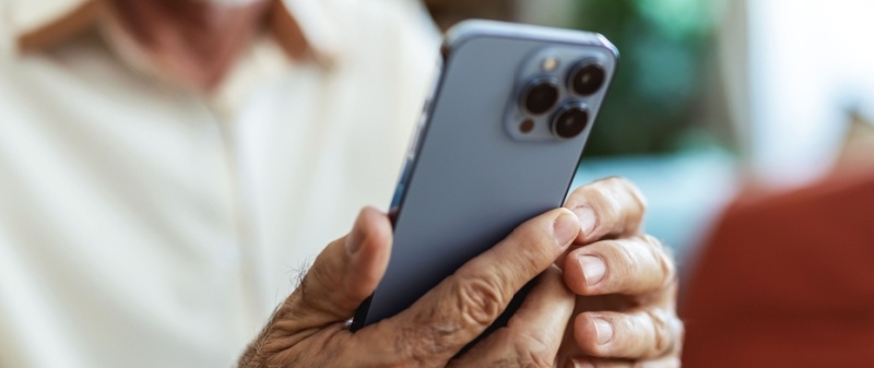 Decorative image - Elderly man reading content on mobile phone