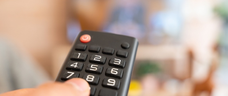 Decorative image - Person pointing remote control at TV