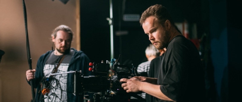 Decorative image - Two film crew working on indoor set