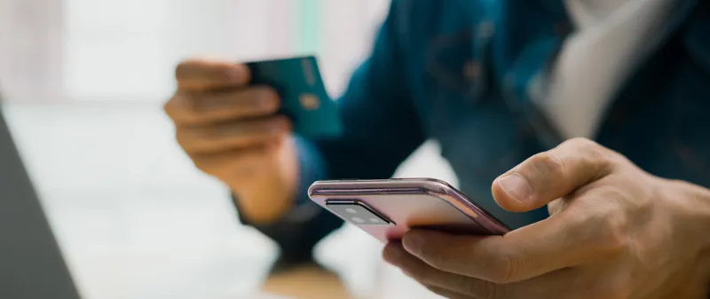 Decorative image - Person using credit card with mobile phone