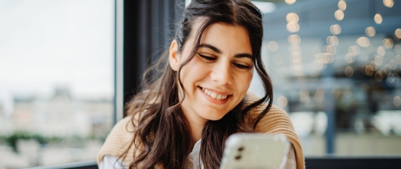 Decorative image - Happy woman looking at mobile phone