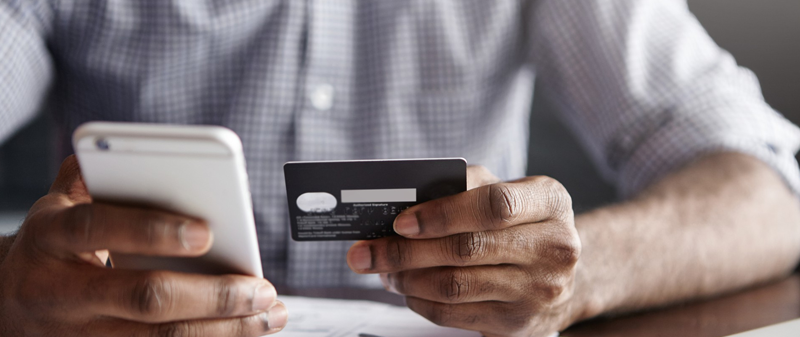 Decorative image - Man holding credit card and mobile phone