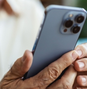 Decorative image - Elderly man reading content on mobile phone