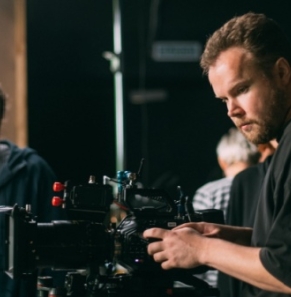Decorative image - Two film crew working on indoor set