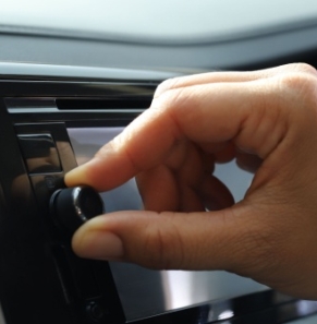 Decorative image - Person turning dial on car radio