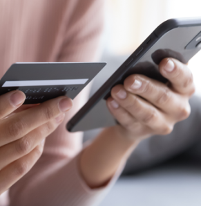 Decorative image - Woman looking at credit card and mobile phone