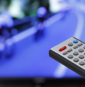 Decorative image - Person holding television remote watching professionsal cycling