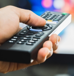 Decorative image - Person holding remote watching TV