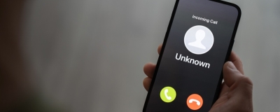 Decorative image - Person holding mobile phone receiving call from unknown source