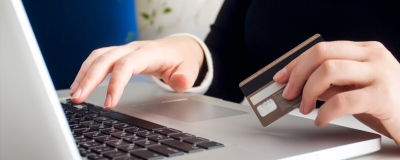 Decorative image - Person using laptop holding credit card