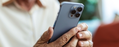 Decorative image - Elderly man reading content on mobile phone