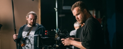 Decorative image - Two film crew working on indoor set