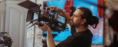 Decorative image - Cameraman adjusting camera