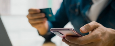 Decorative image - Person using credit card with mobile phone