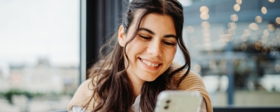 Decorative image - Happy woman looking at mobile phone