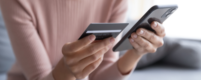 Decorative image - Woman looking at credit card and mobile phone