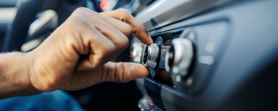 Decorative image - Person adjusting radio in car