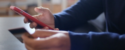 Decorative image - Person checking phone and credit card