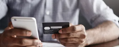 Decorative image - Man holding credit card and mobile phone