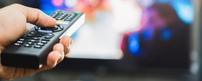 Decorative image - Person holding remote watching TV