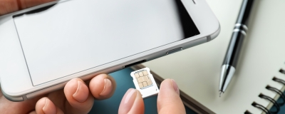 Decorative image - Woman inserting SIM card into phone