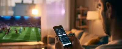 Decorative image - Man doing interactive gambling on phone whilst watching sport on TV
